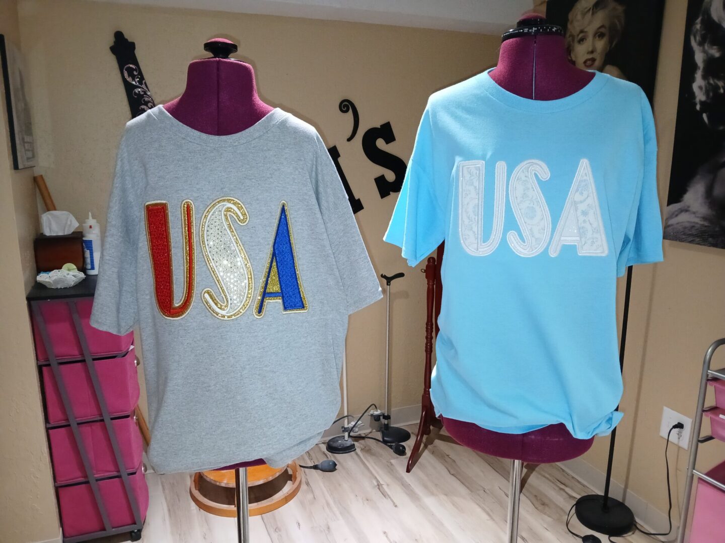 Two dress forms displaying USA T-shirts