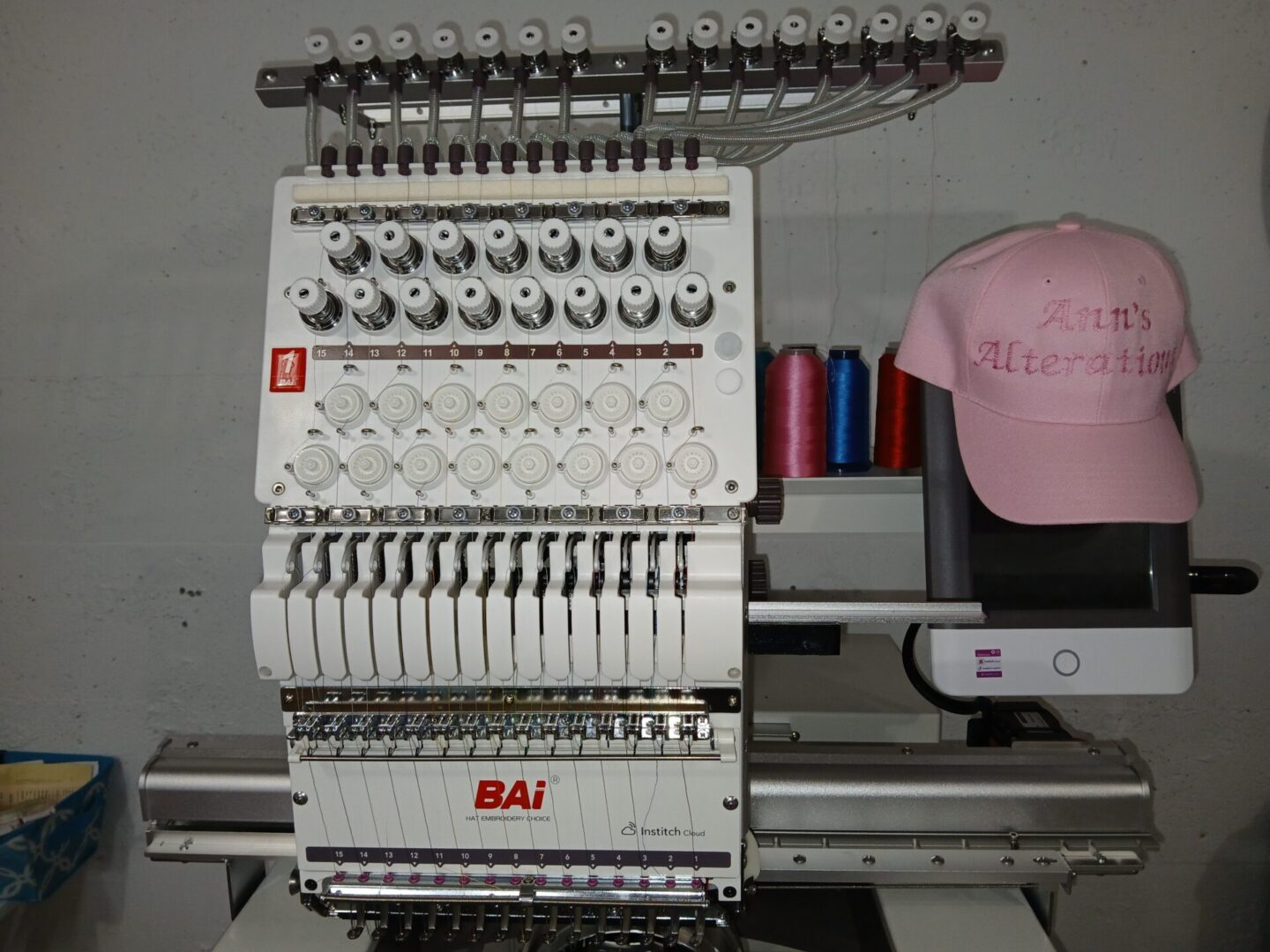 Embroidery machine with pink embroidered cap